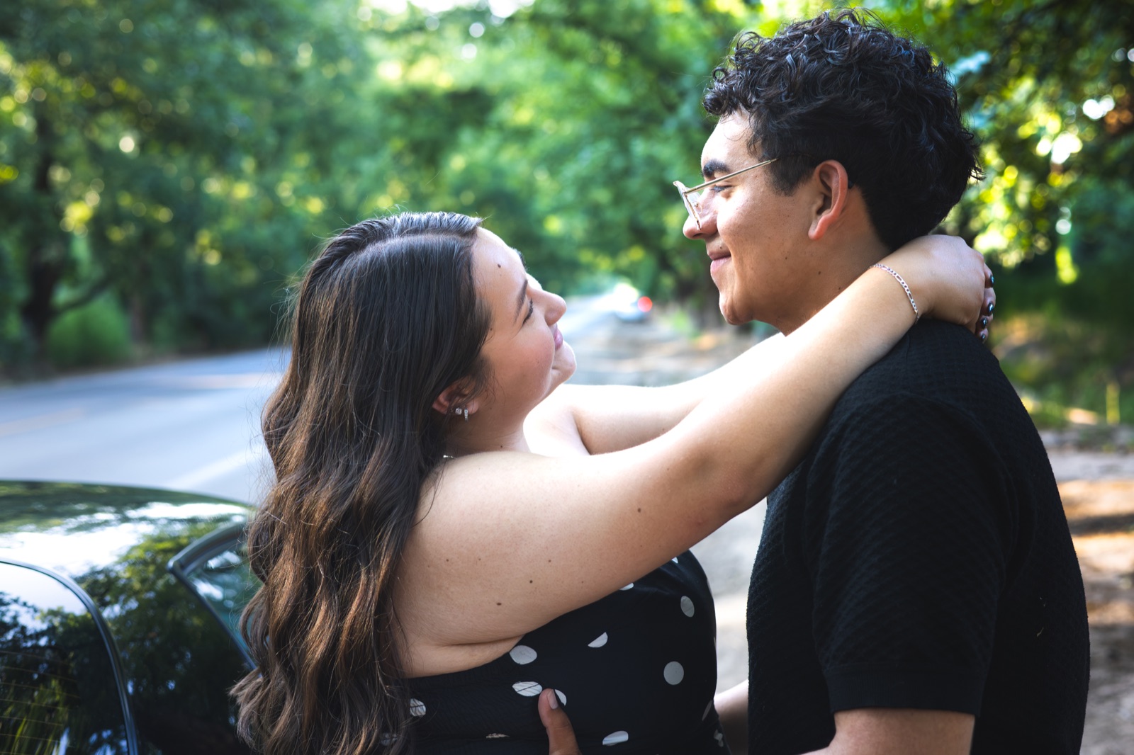 A couple embracing along a leafy road