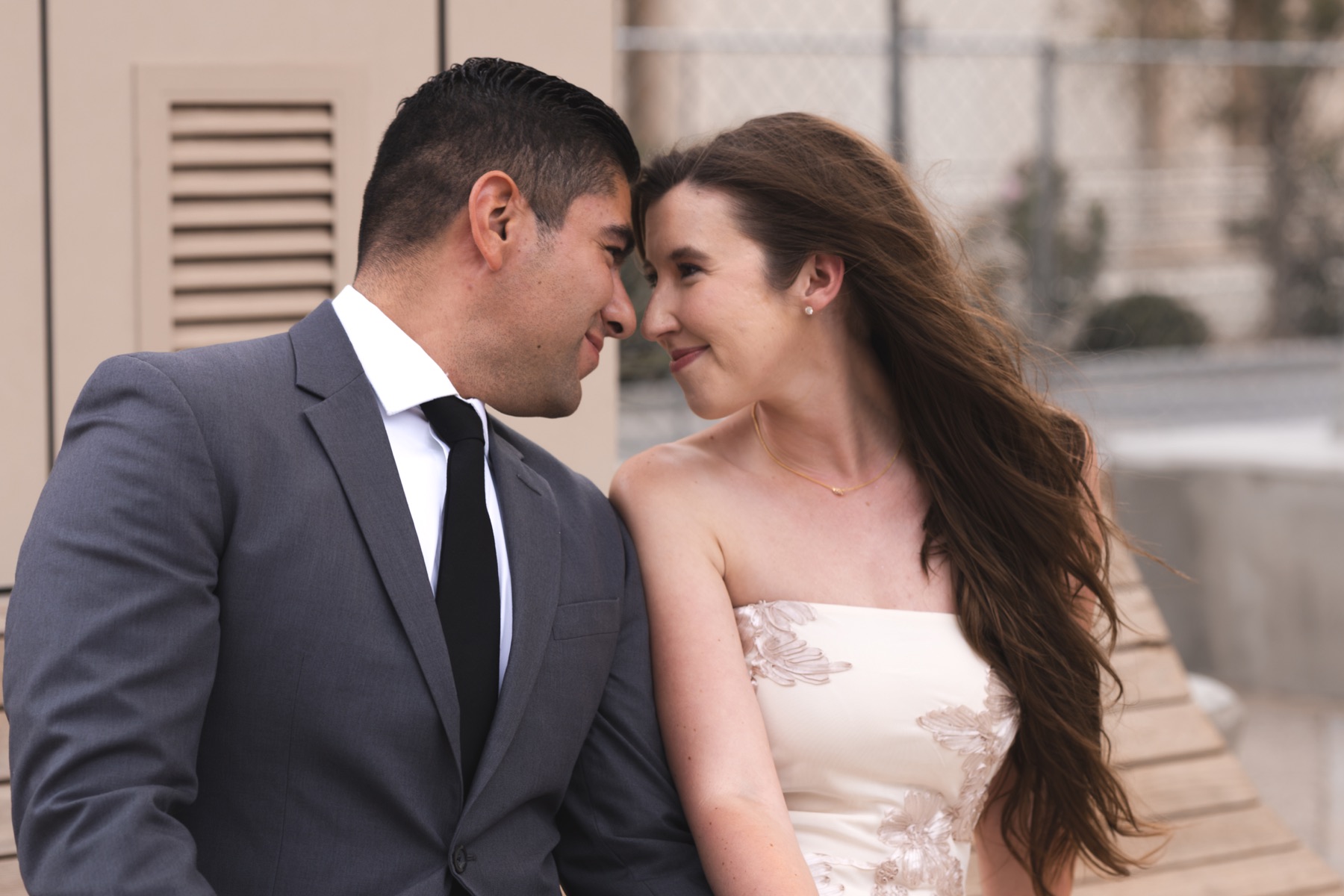 Andrew and Meghan sharing a close moment beside a brick wall