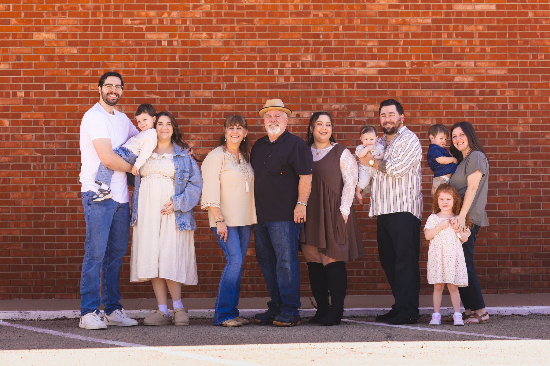 The Taylor family together in front of a red brick wall
