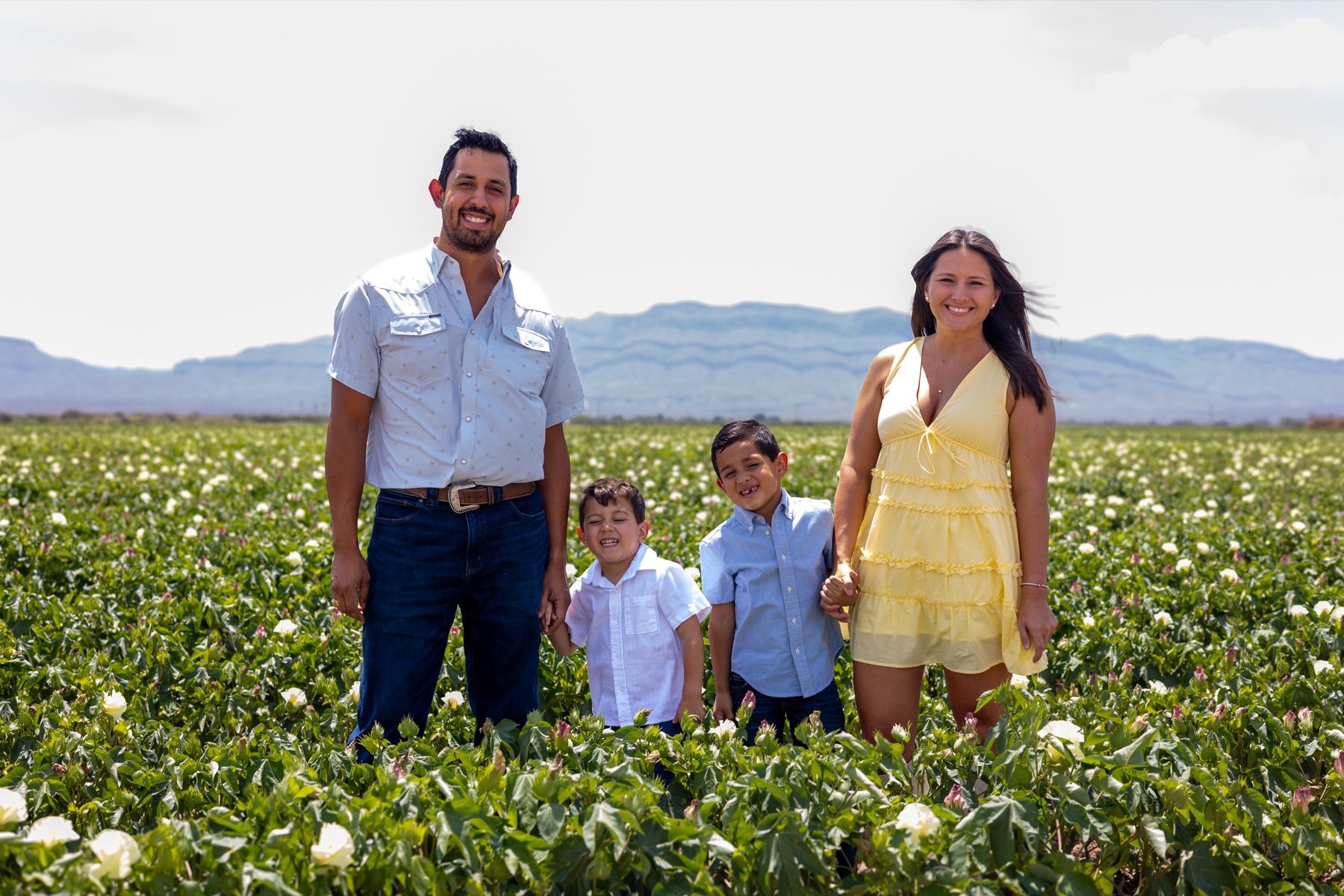 Parents and their two sons smiling together in a flower field