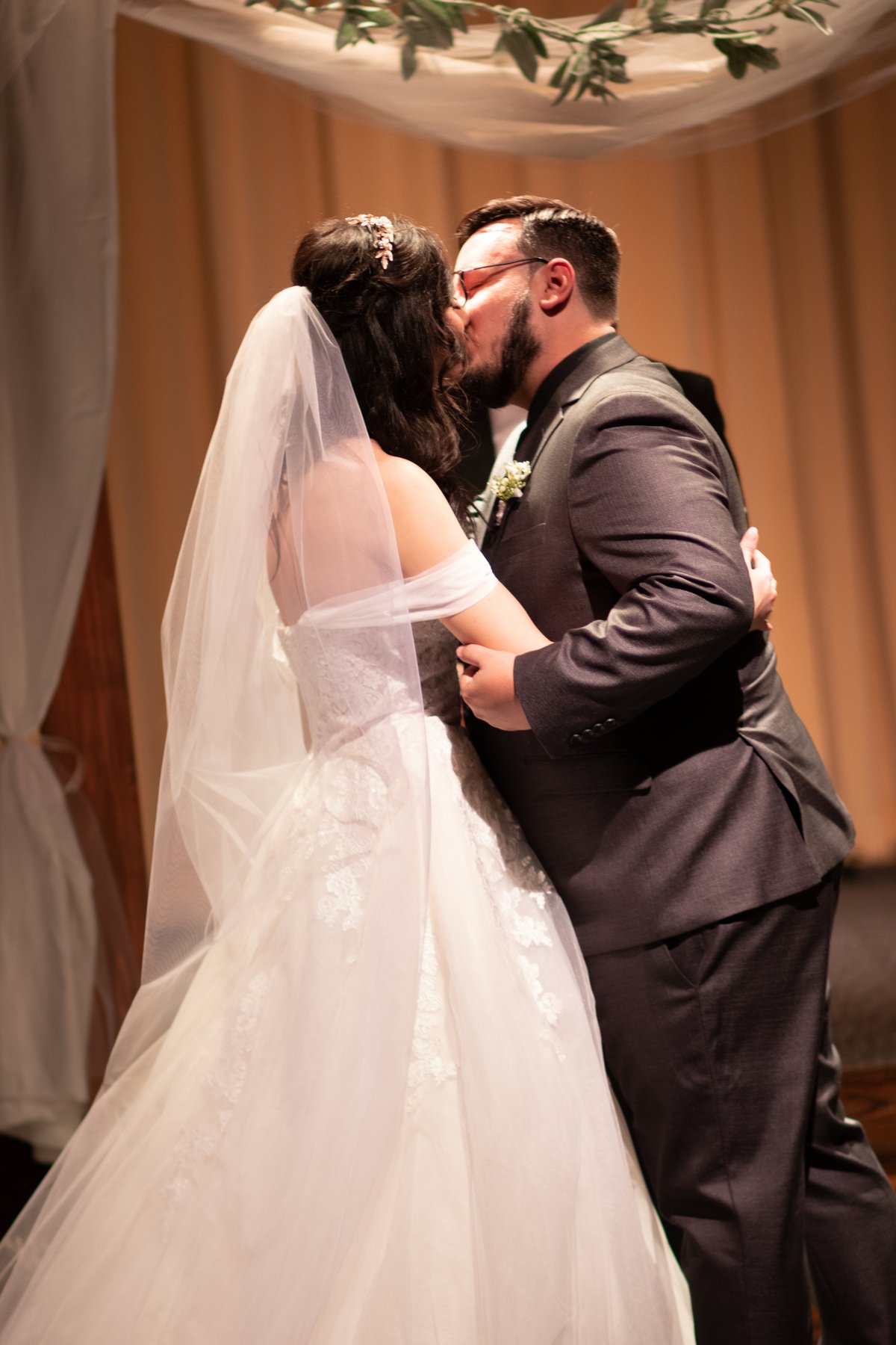 Jackie and Julian sharing a kiss at their wedding ceremony