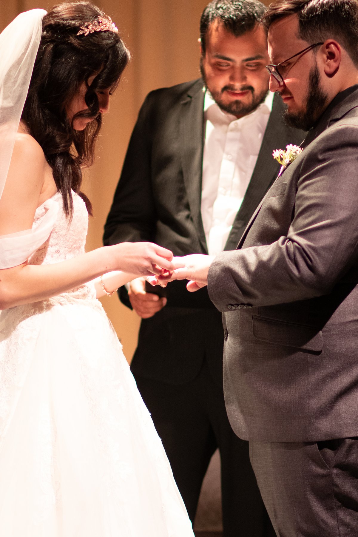 Jackie placing a ring on Julian’s hand during their wedding ceremony