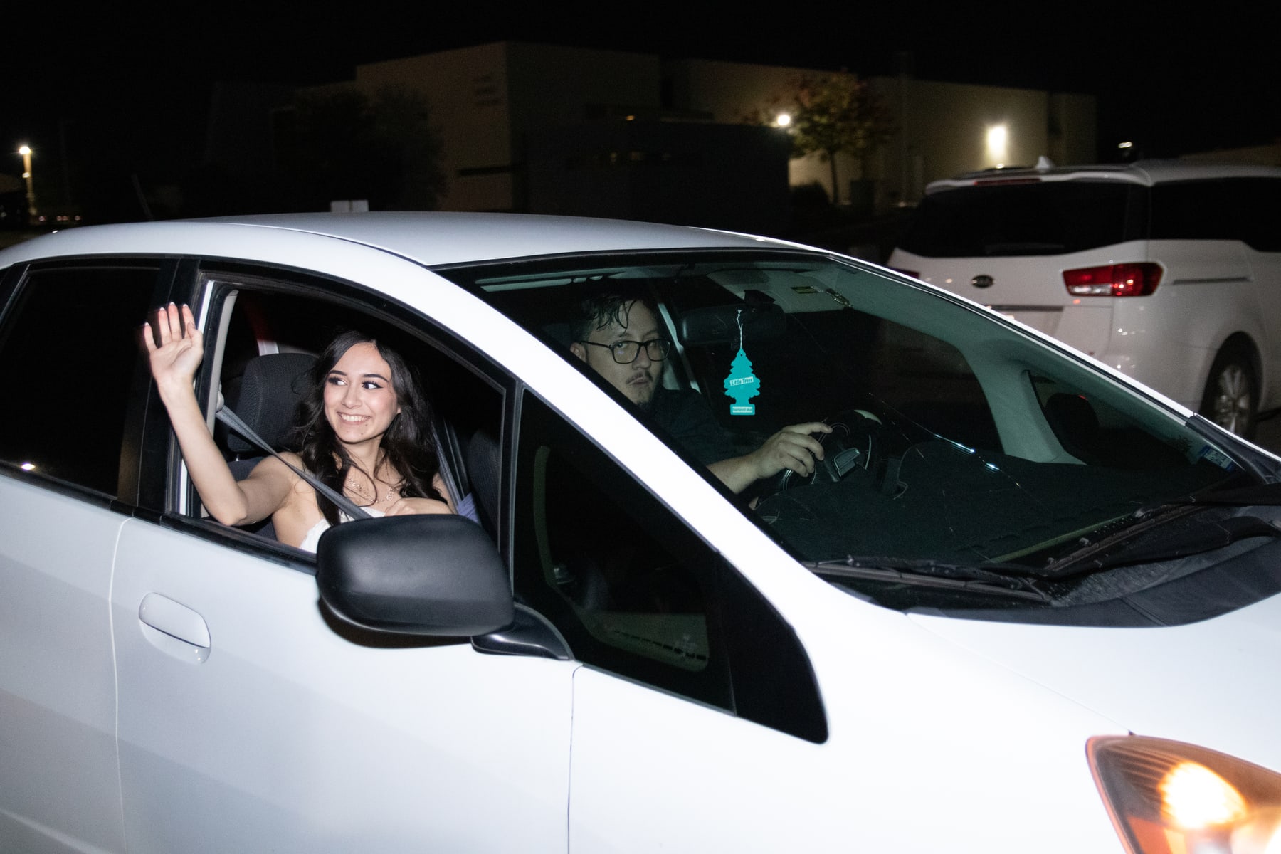 A bride waving from a car window