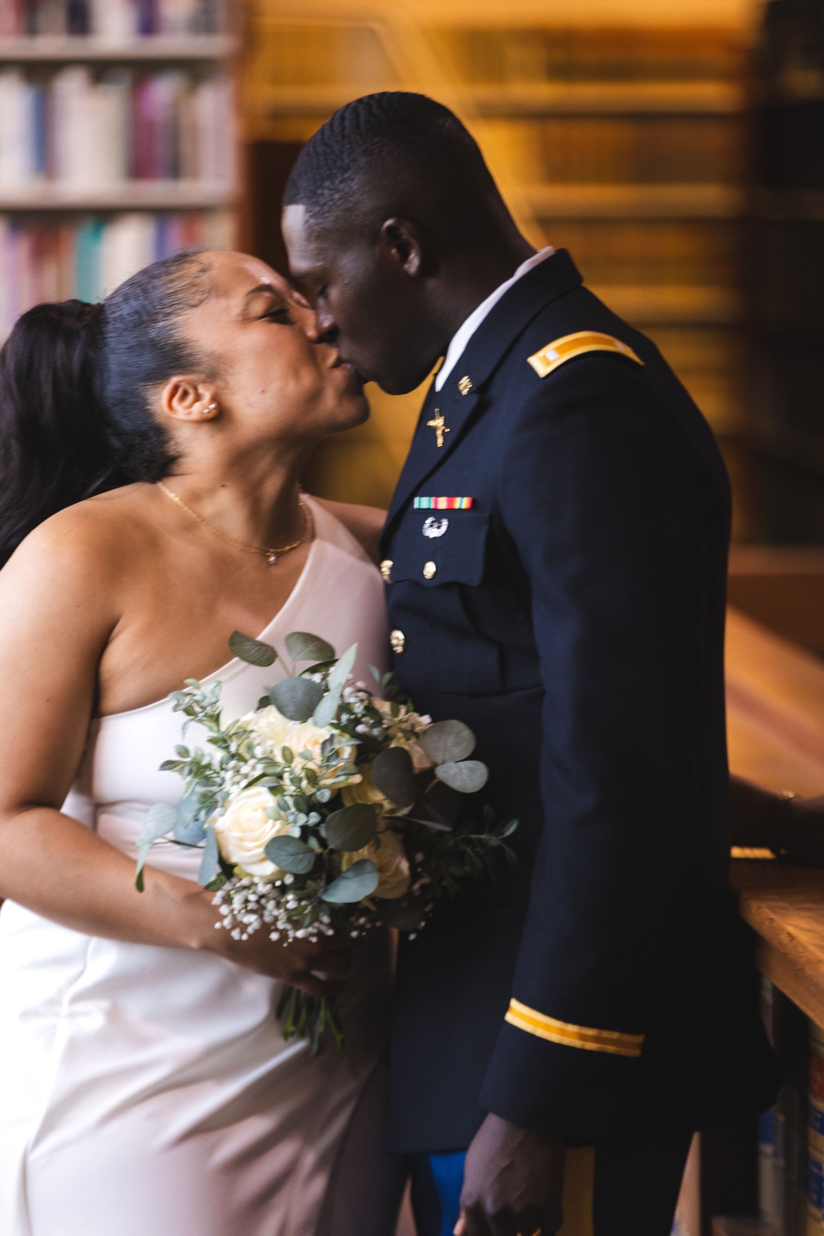 Newlyweds sharing an embrace with a white rose bouquet